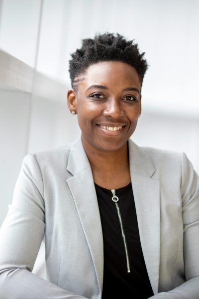 Confident African American businesswoman smiling inside a modern office space.